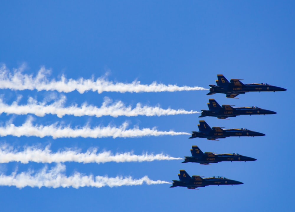 four fighter planes flying in the sky during daytime