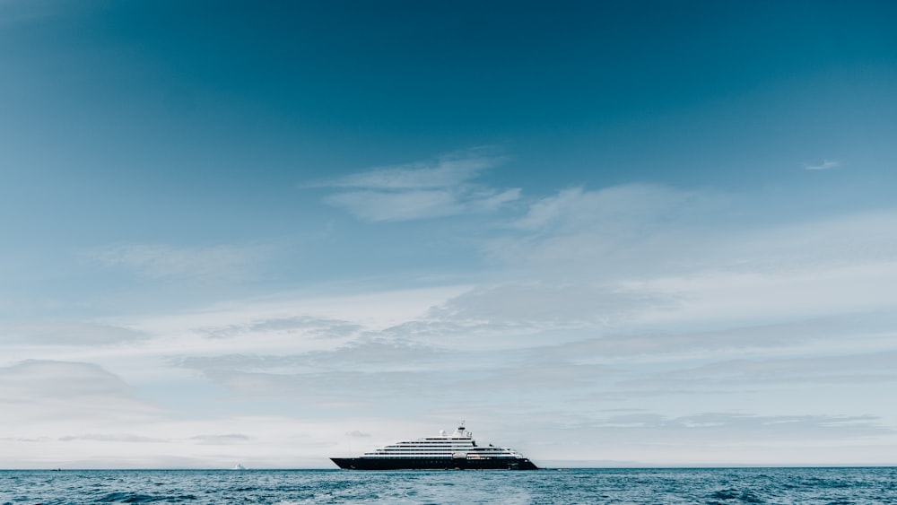 navio branco e preto no mar sob o céu azul durante o dia