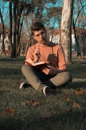 A thoughtful person journaling in a peaceful park setting.