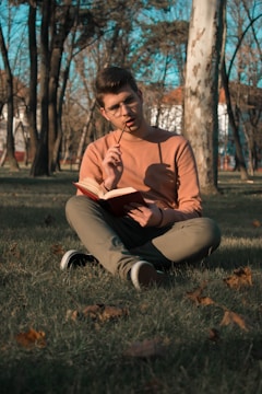A thoughtful person journaling in a peaceful park setting.