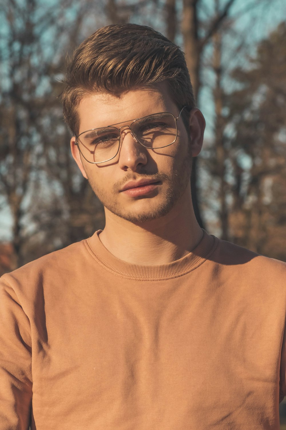 man in orange crew neck shirt wearing black framed eyeglasses