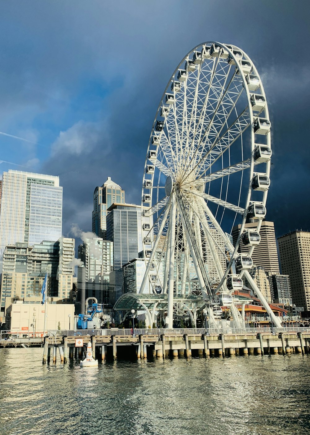 white ferris wheel near city buildings during daytime