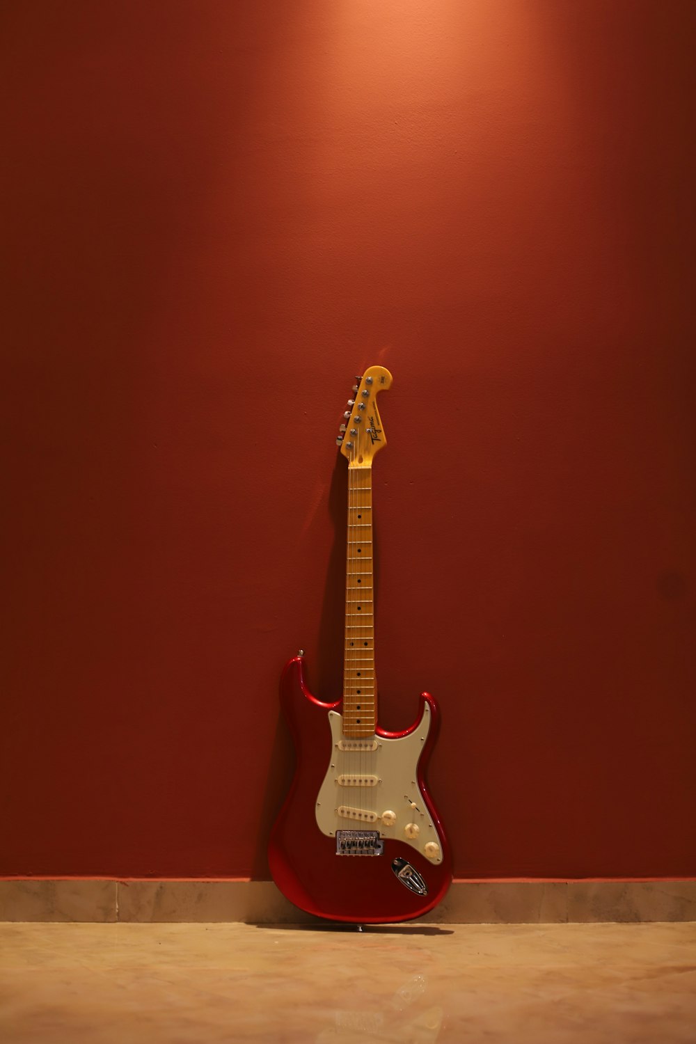 white and brown stratocaster electric guitar