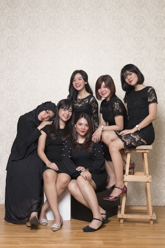 3 women sitting on brown wooden chair