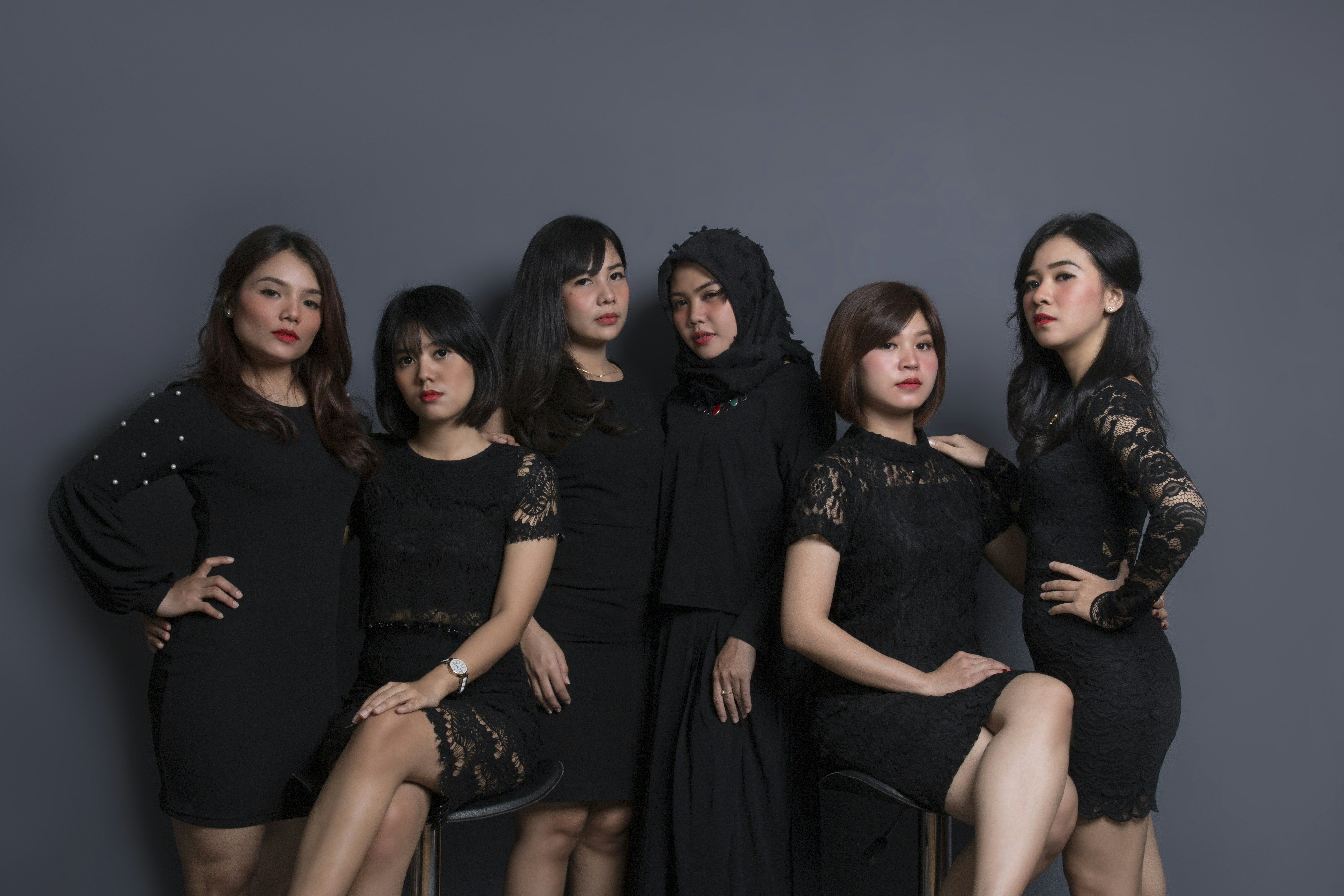 3 women sitting on black couch