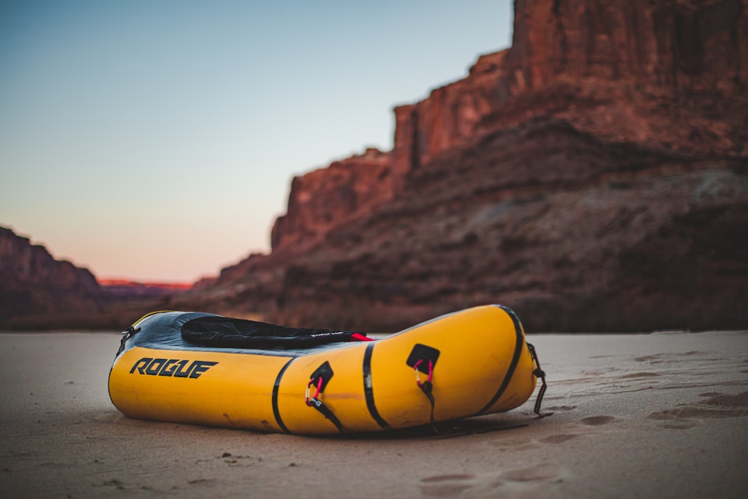 yellow and black surfboard on brown sand during daytime