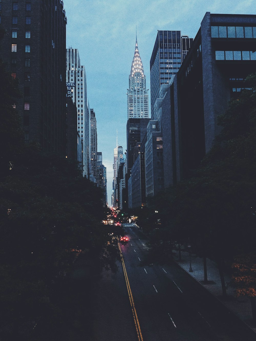 cars on road between high rise buildings during daytime