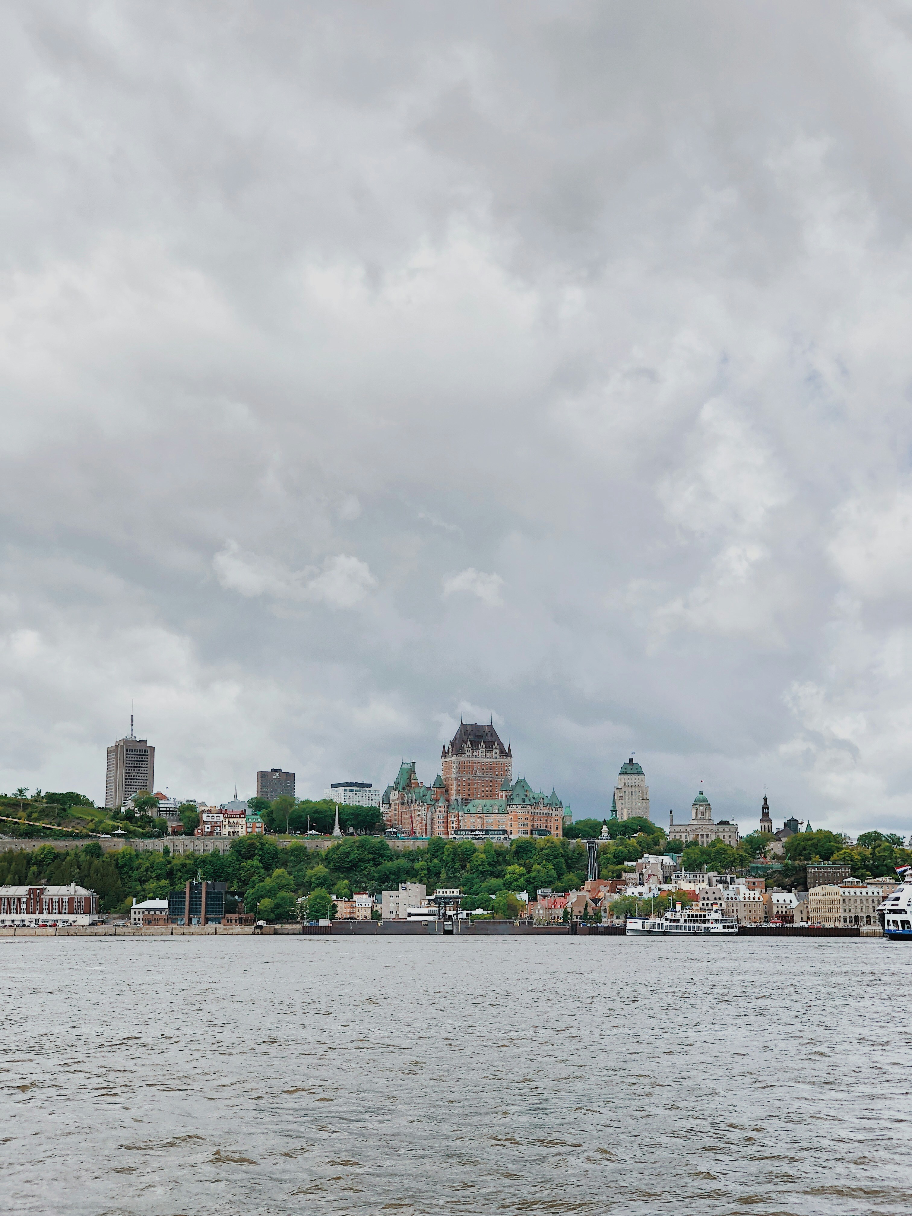 city buildings near body of water under cloudy sky during daytime