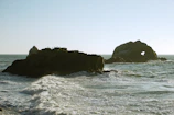 Rock formations along the Atlantic coast with seagulls flying overhead on a clear day.