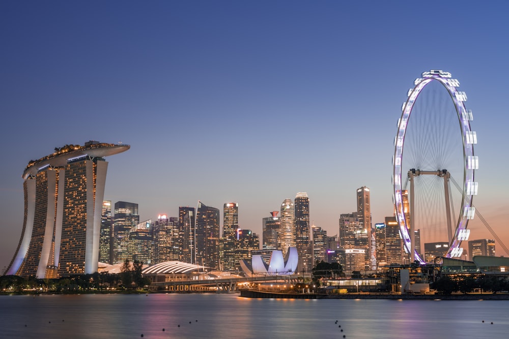 ferris wheel near city buildings during night time