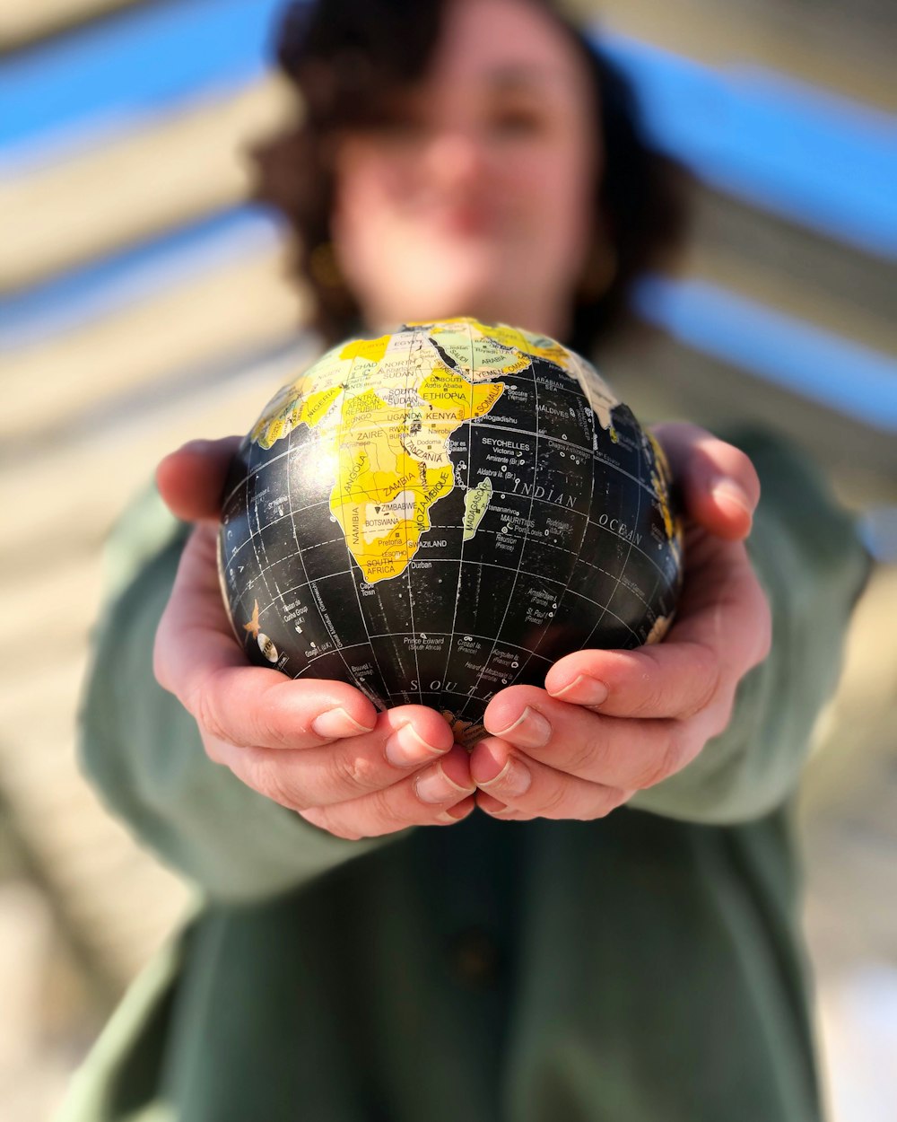 person holding yellow and black desk globe