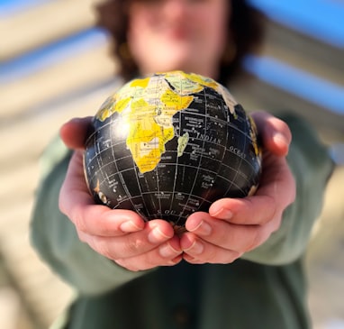 person holding yellow and black desk globe