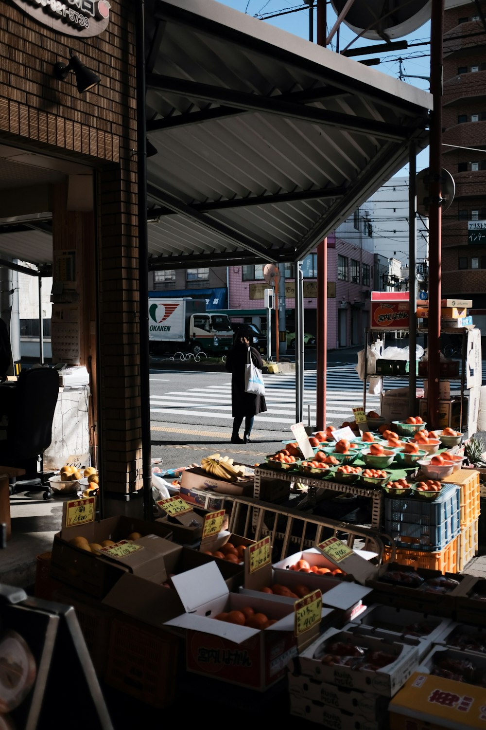 woman in black jacket standing near food stall during daytime