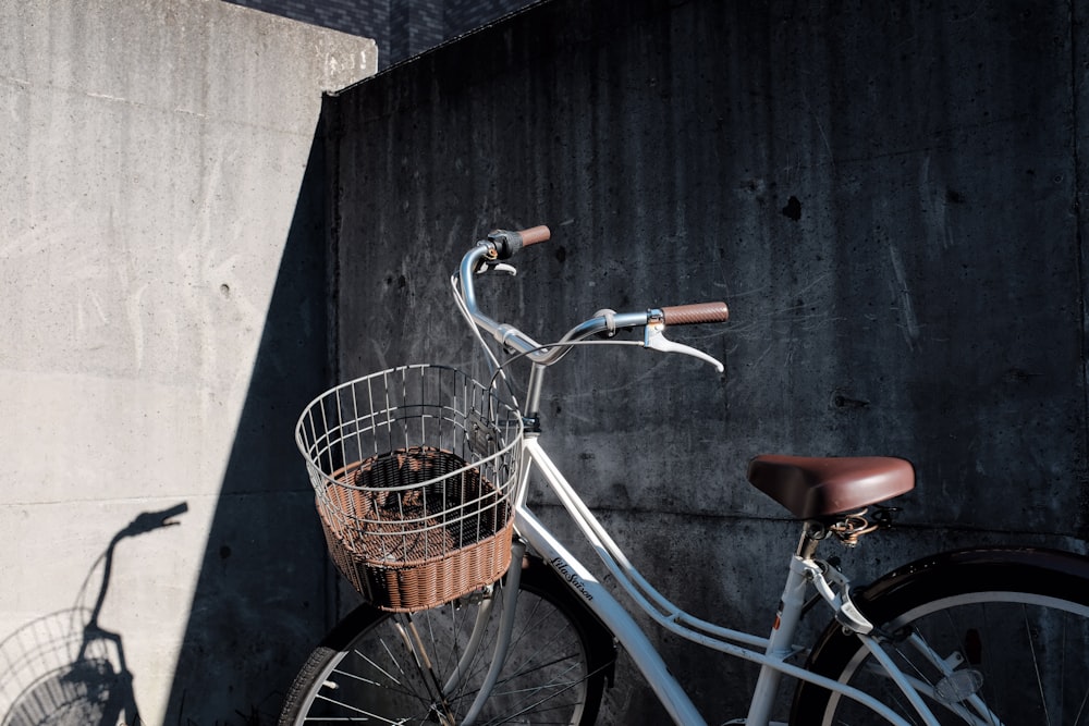 blue city bike with basket on black wooden wall