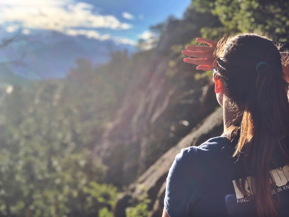 woman in black shirt standing on mountain during daytime