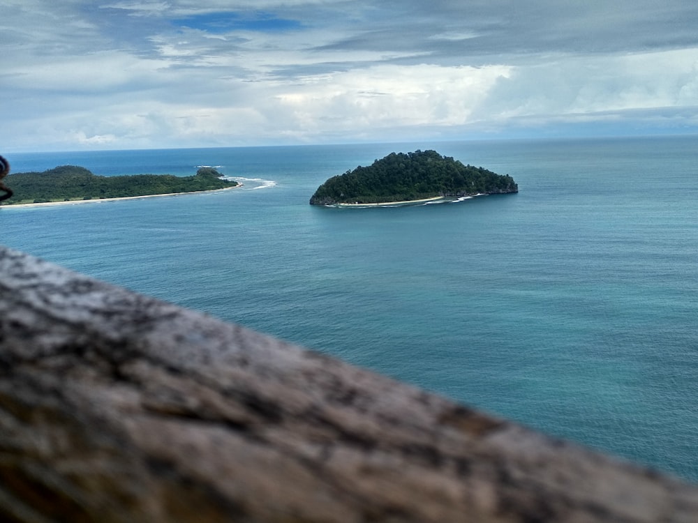 green island in the middle of blue sea under blue sky during daytime