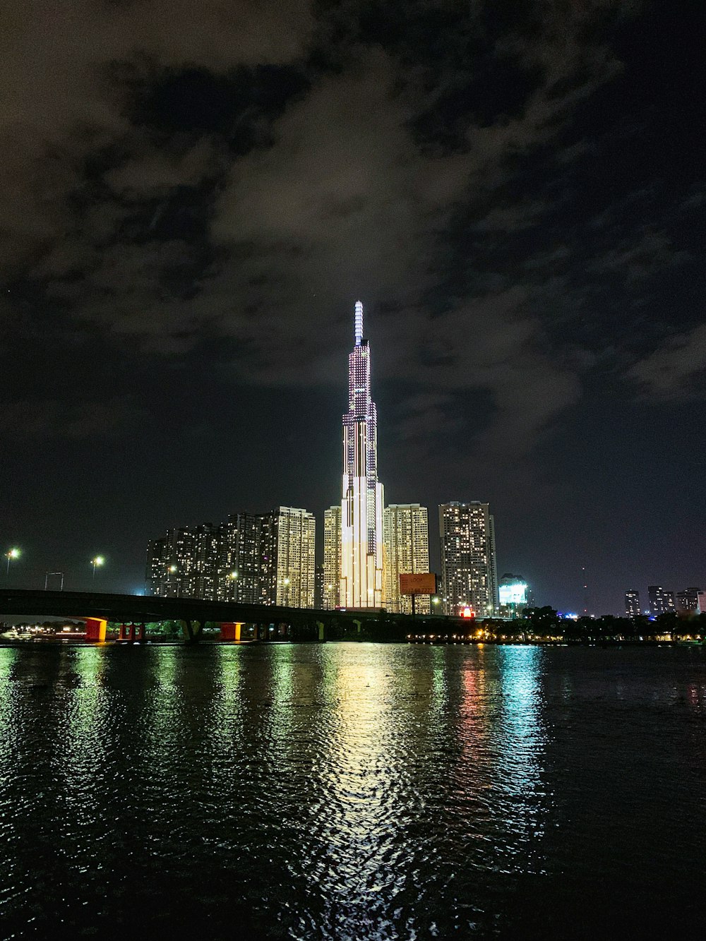 city skyline across body of water during night time