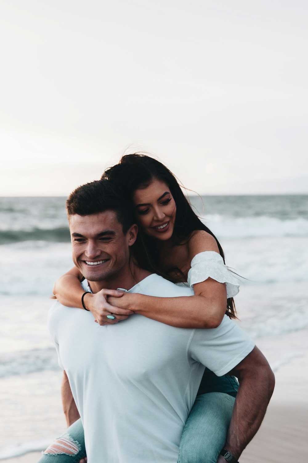 Mujer en camisa blanca abrazando a hombre en camisa blanca