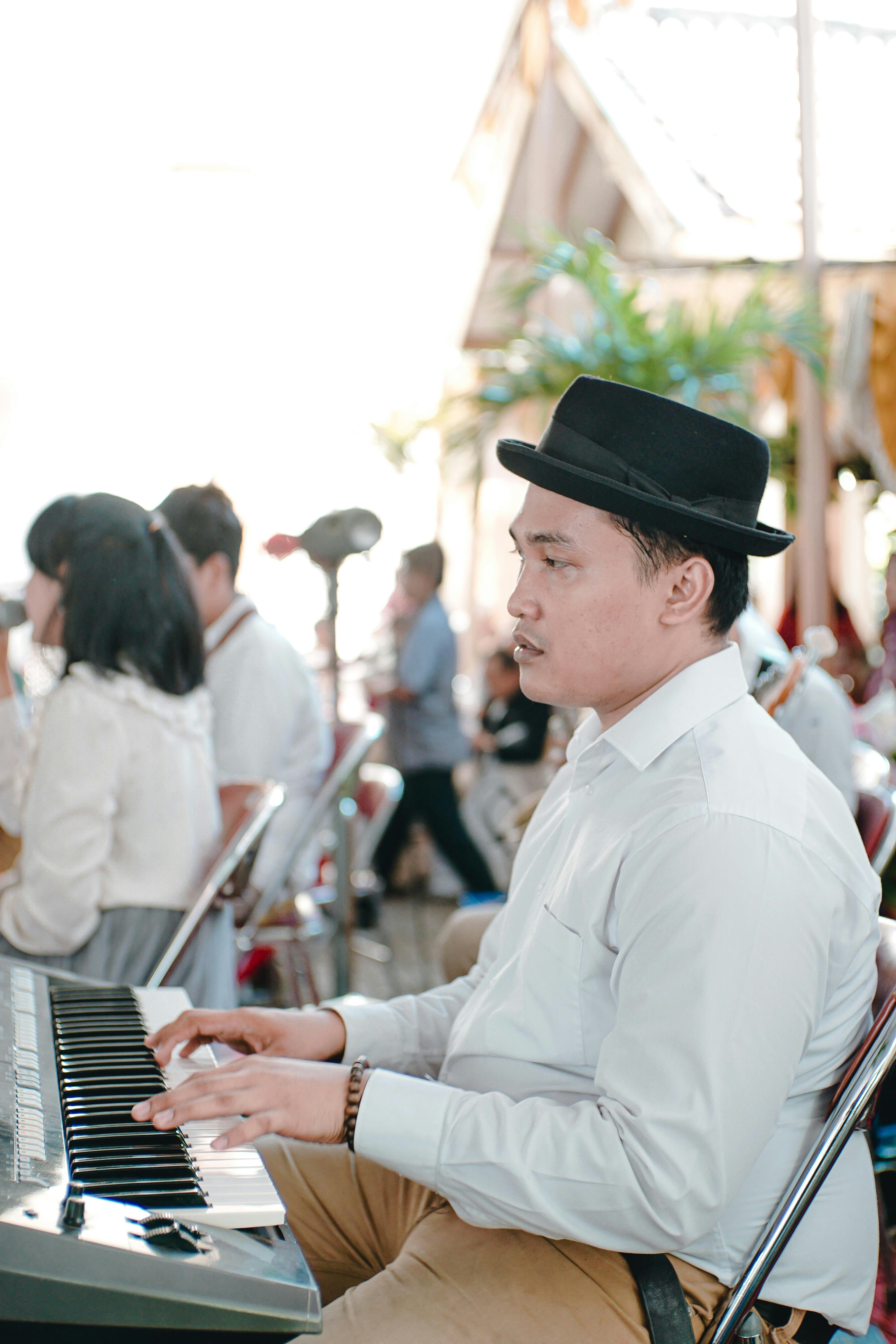 man in white dress shirt playing piano