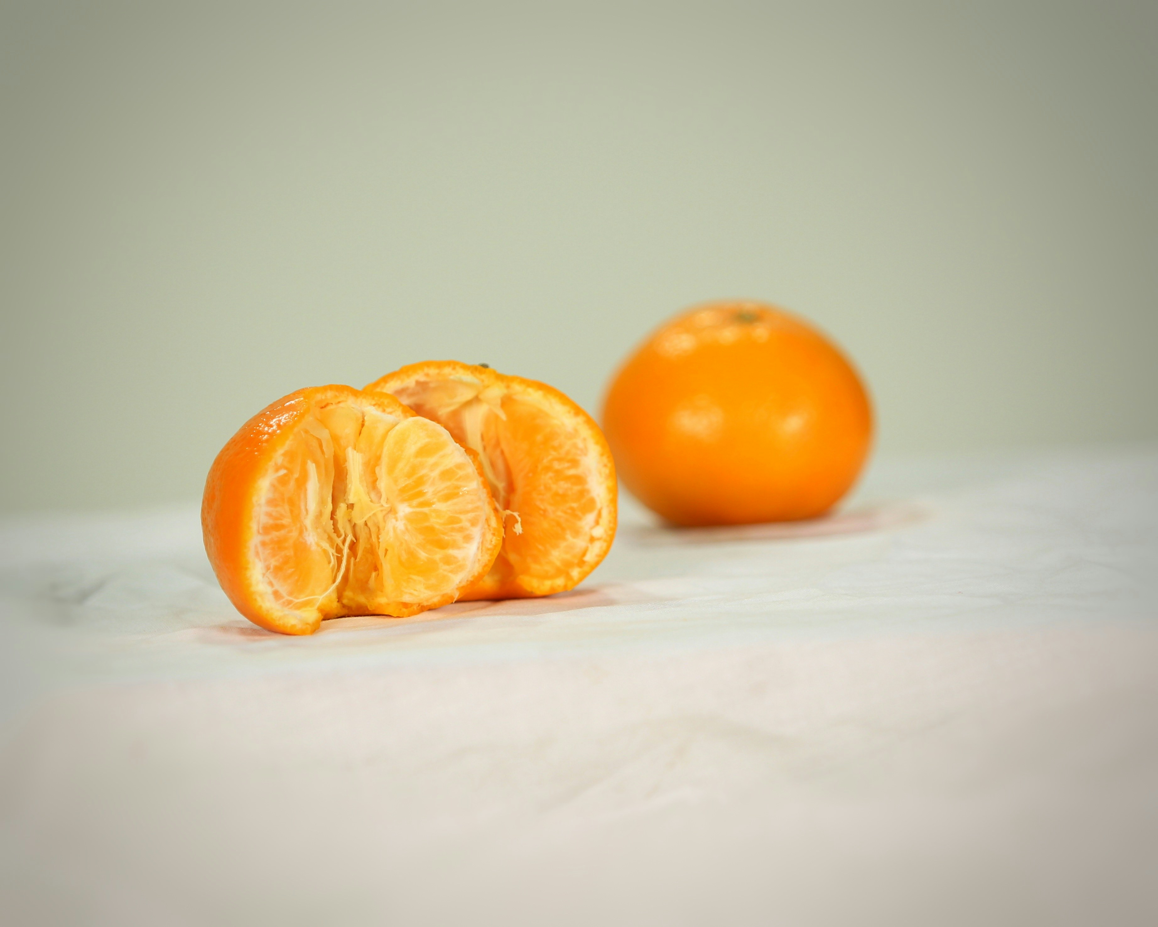 2 orange fruits on white textile