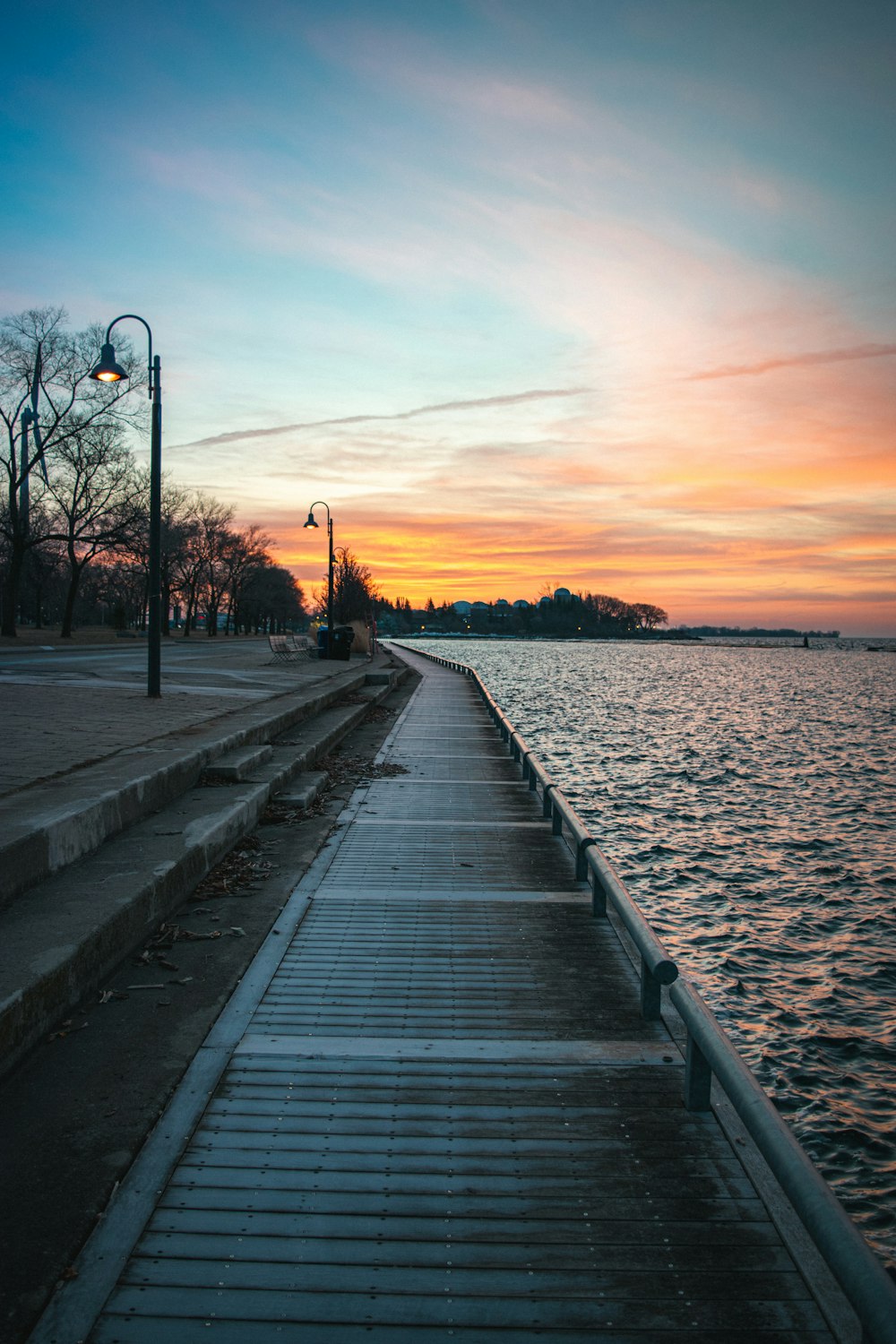 Quai en bois brun sur le plan d’eau au coucher du soleil