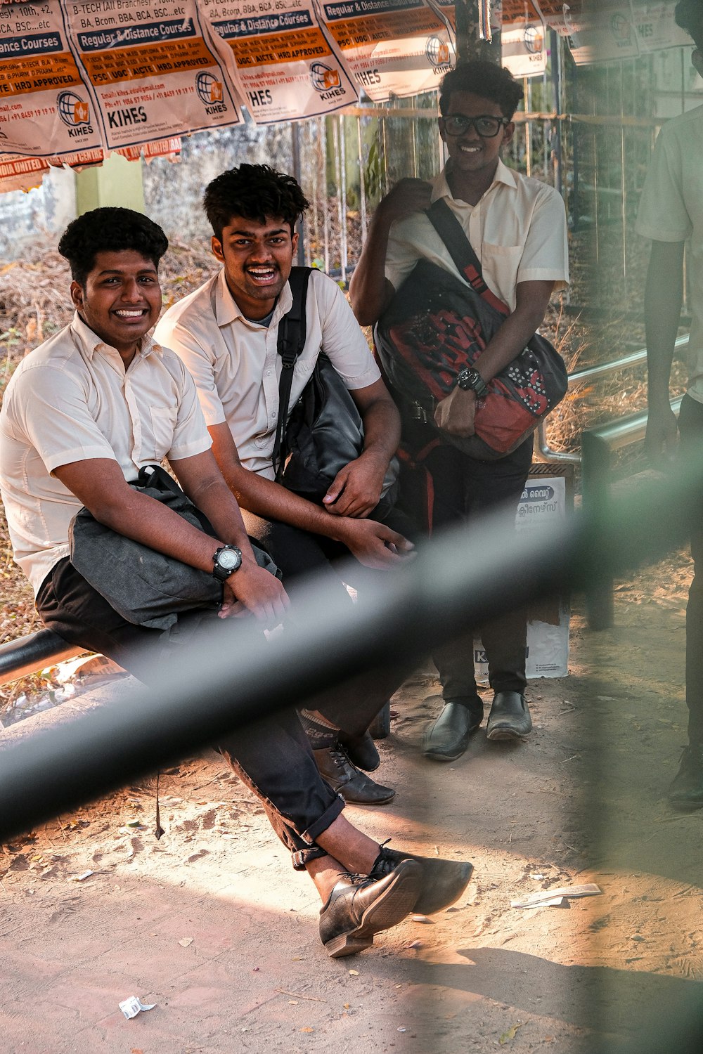 2 men sitting on brown wooden bench