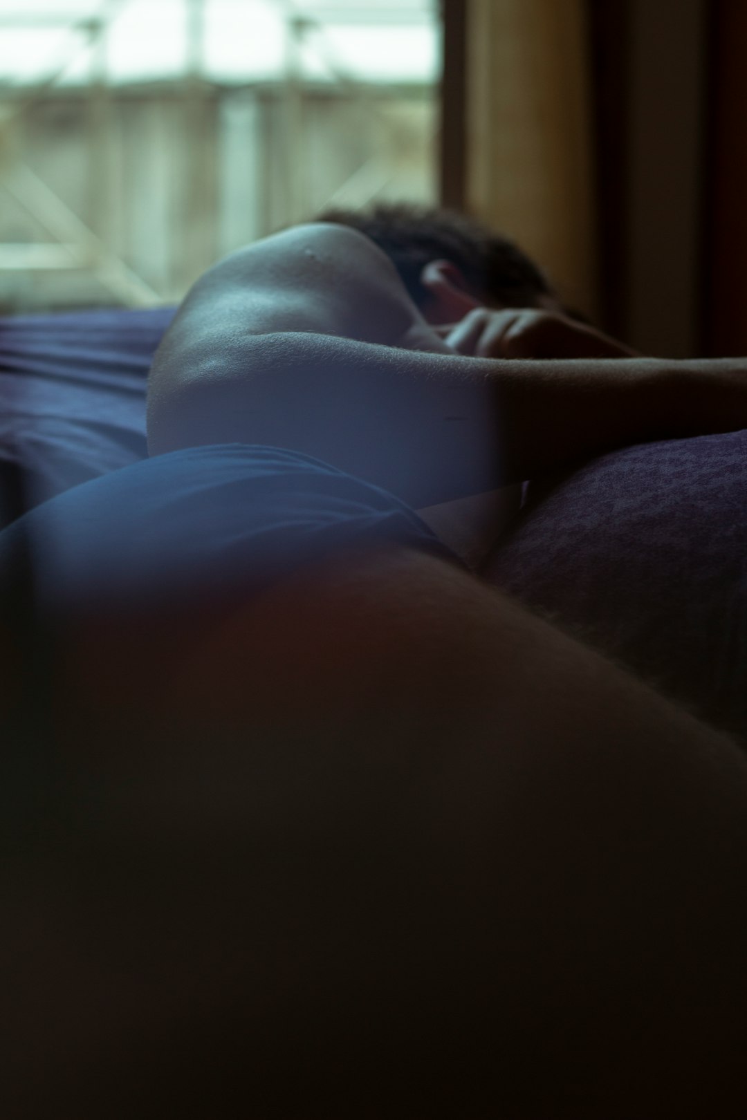 woman lying on bed near window