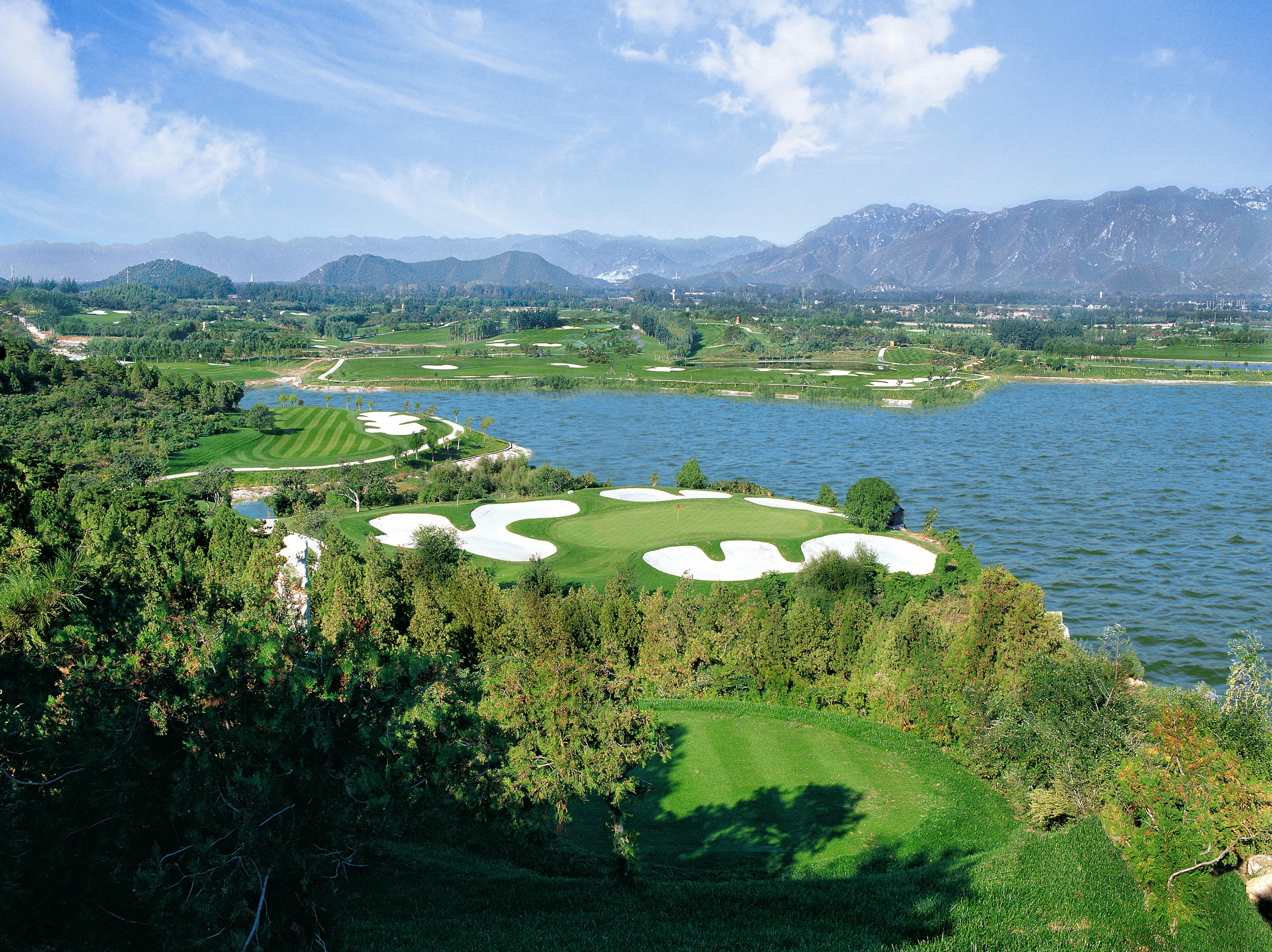 green grass field near body of water during daytime