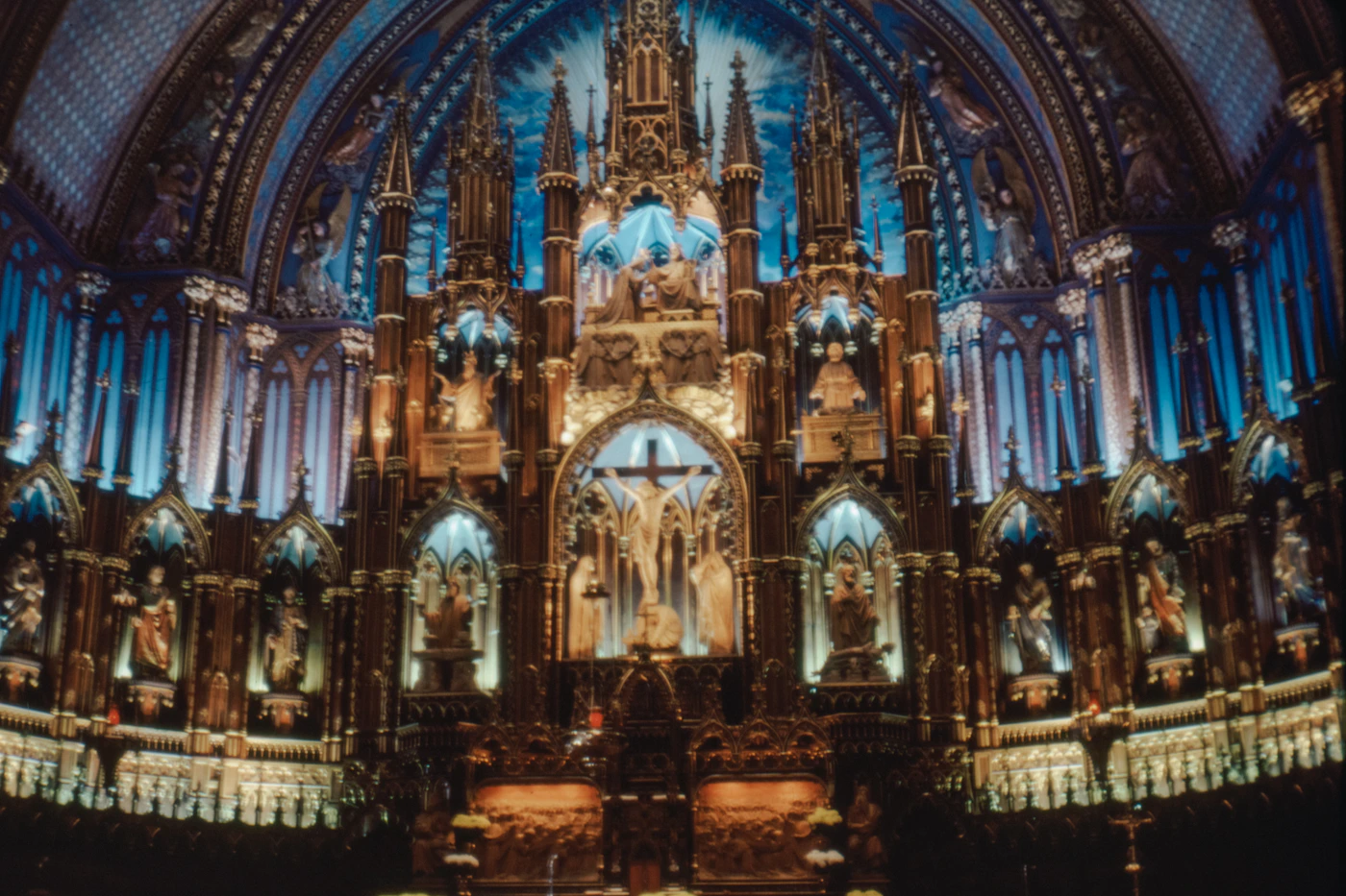 Notre-Dame Basilica of Montreal interior showing the luminous blue and gold vaulted ceiling, carved wooden galleries, and stained glass windows