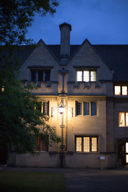 Historic stone entrance of Marmion Lodge with a warm glow at dusk.