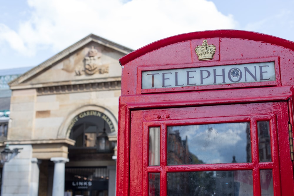 red telephone booth near building during daytime