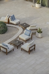 Serene outdoor patio with minimalist furniture and greenery.