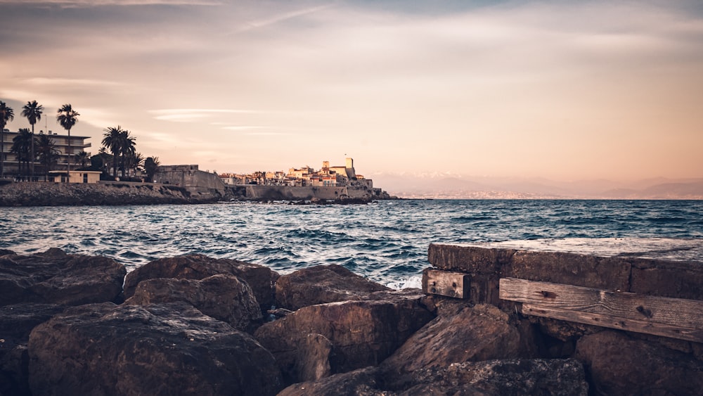 formação rochosa marrom no mar durante o dia