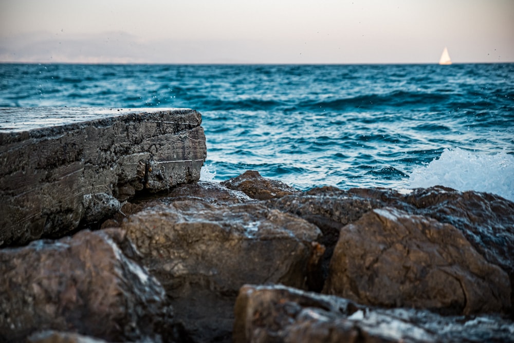 brown and gray rock formation near body of water during daytime