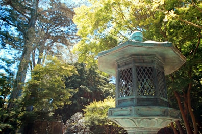 Intricately designed brass and wooden garden decor under natural sunlight.