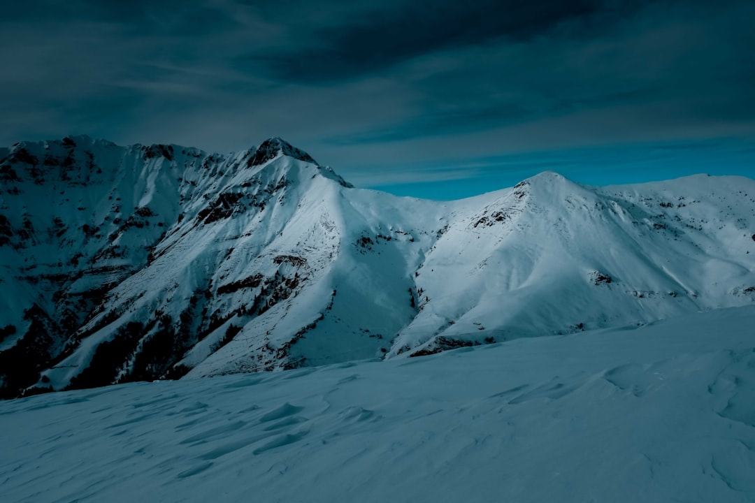 snow covered mountain under cloudy sky during daytime