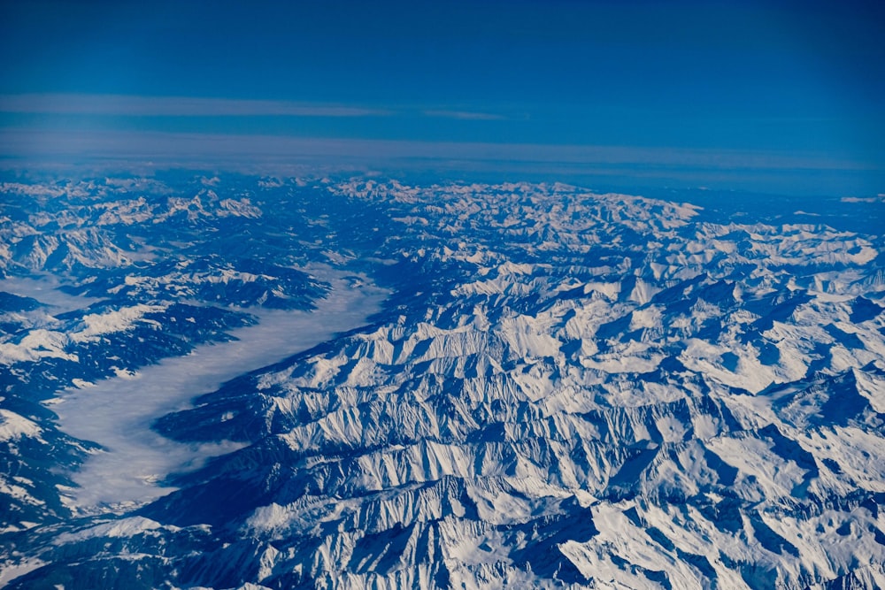 white clouds over snow covered mountains during daytime