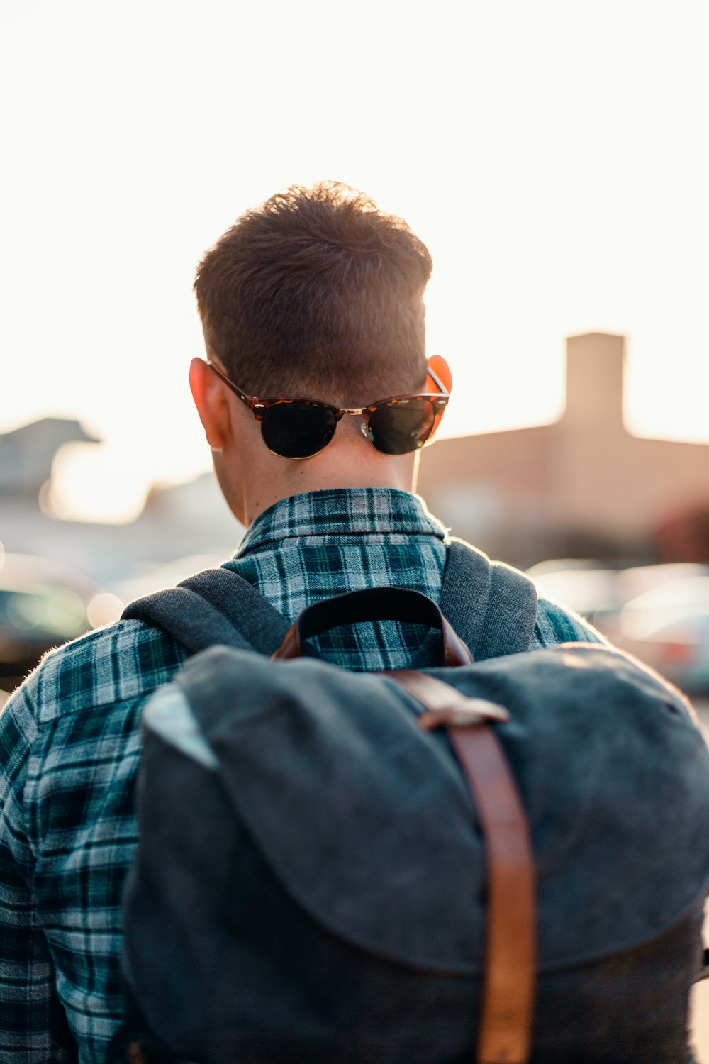 man in blue and white plaid dress shirt wearing black sunglasses