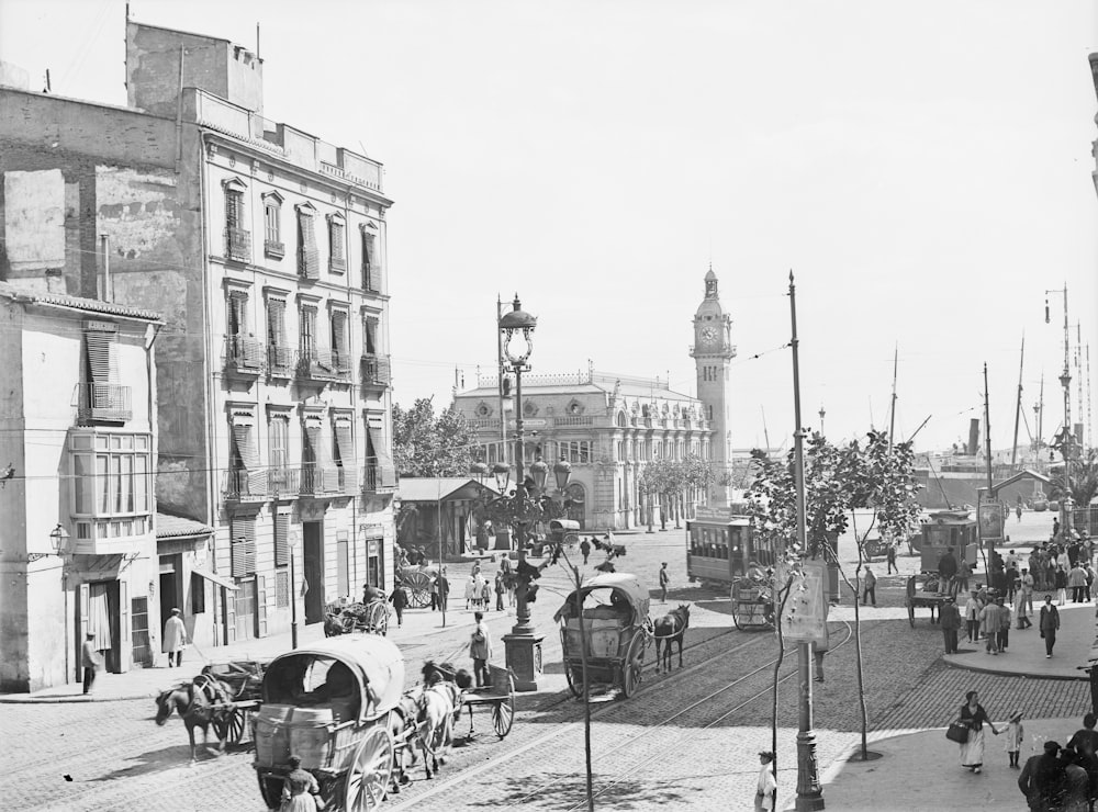 grayscale photo of people walking on street near buildings