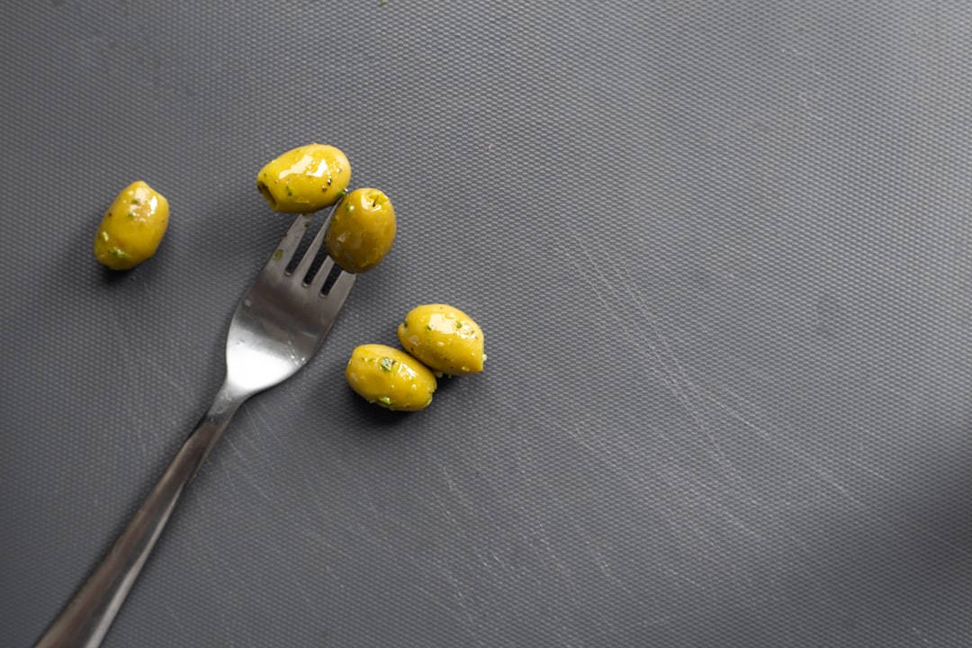 yellow round fruit beside stainless steel fork