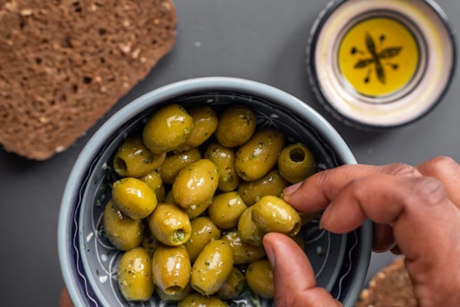 green and yellow round fruits in stainless steel bowl
