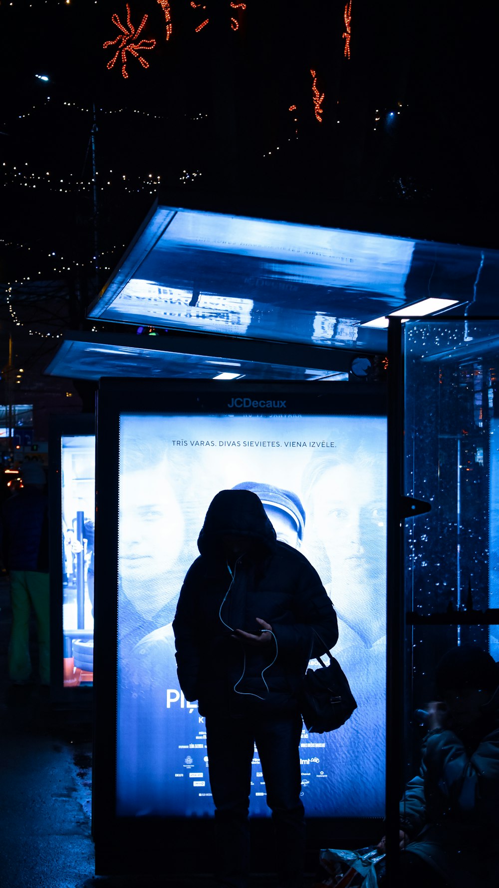 woman in black hoodie standing in front of black flat screen tv