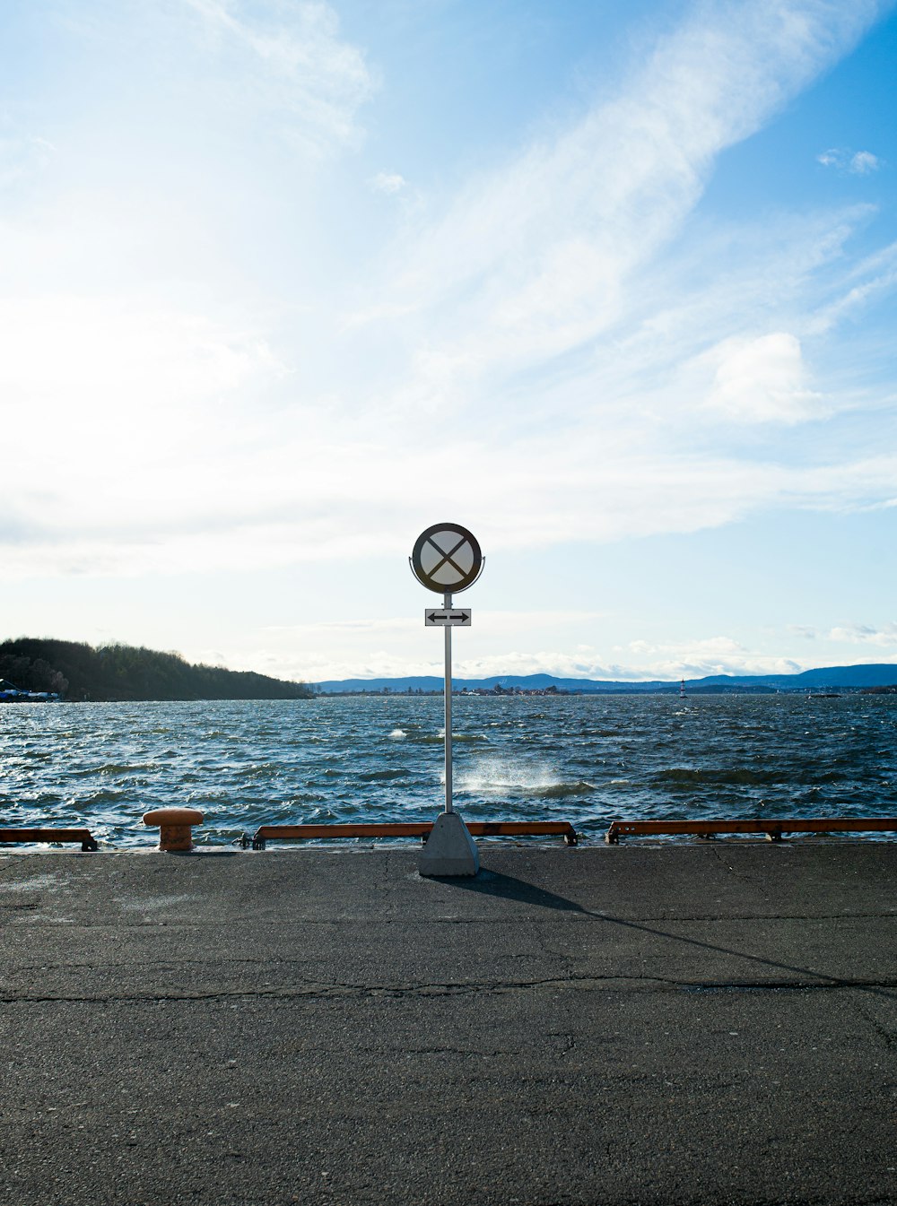 black and white street lamp near body of water during daytime