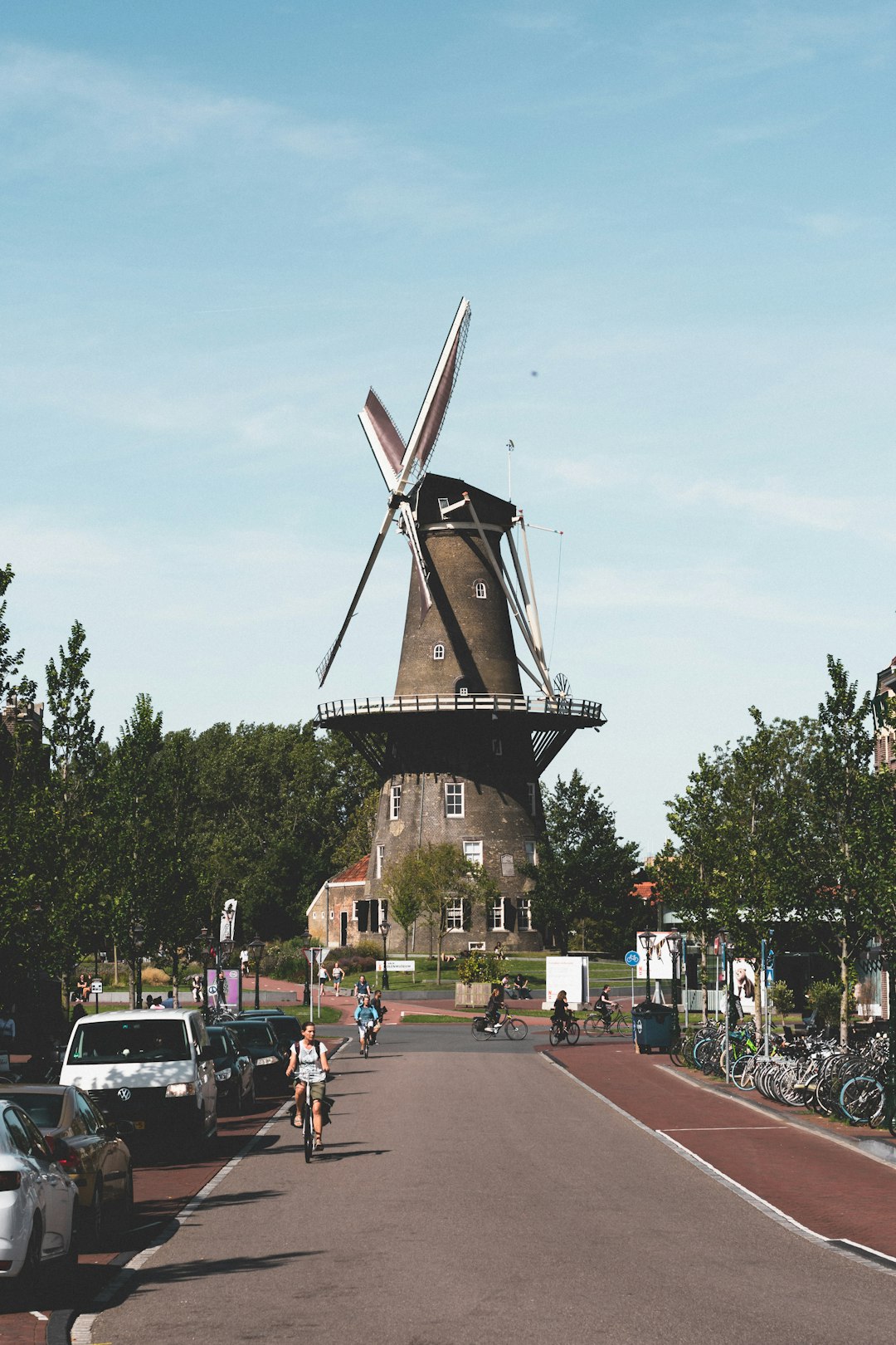 people walking on street near brown windmill during daytime