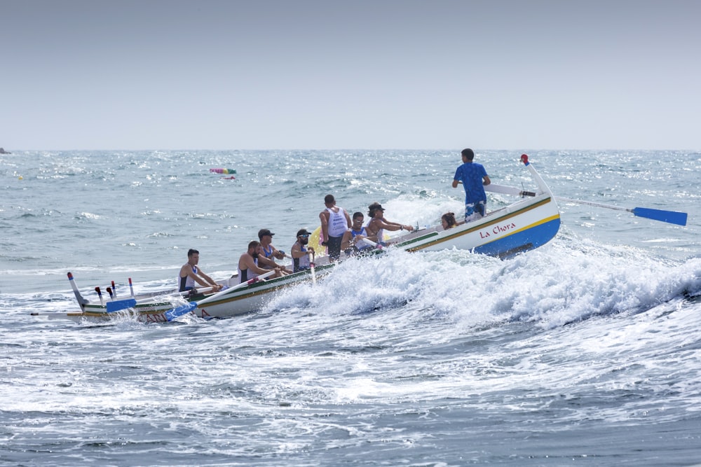 personnes à bord d’un bateau bleu et jaune pendant la journée
