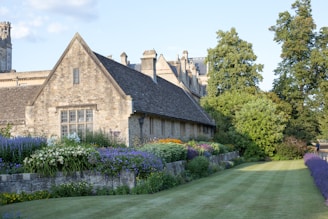 brown brick house near green trees during daytime