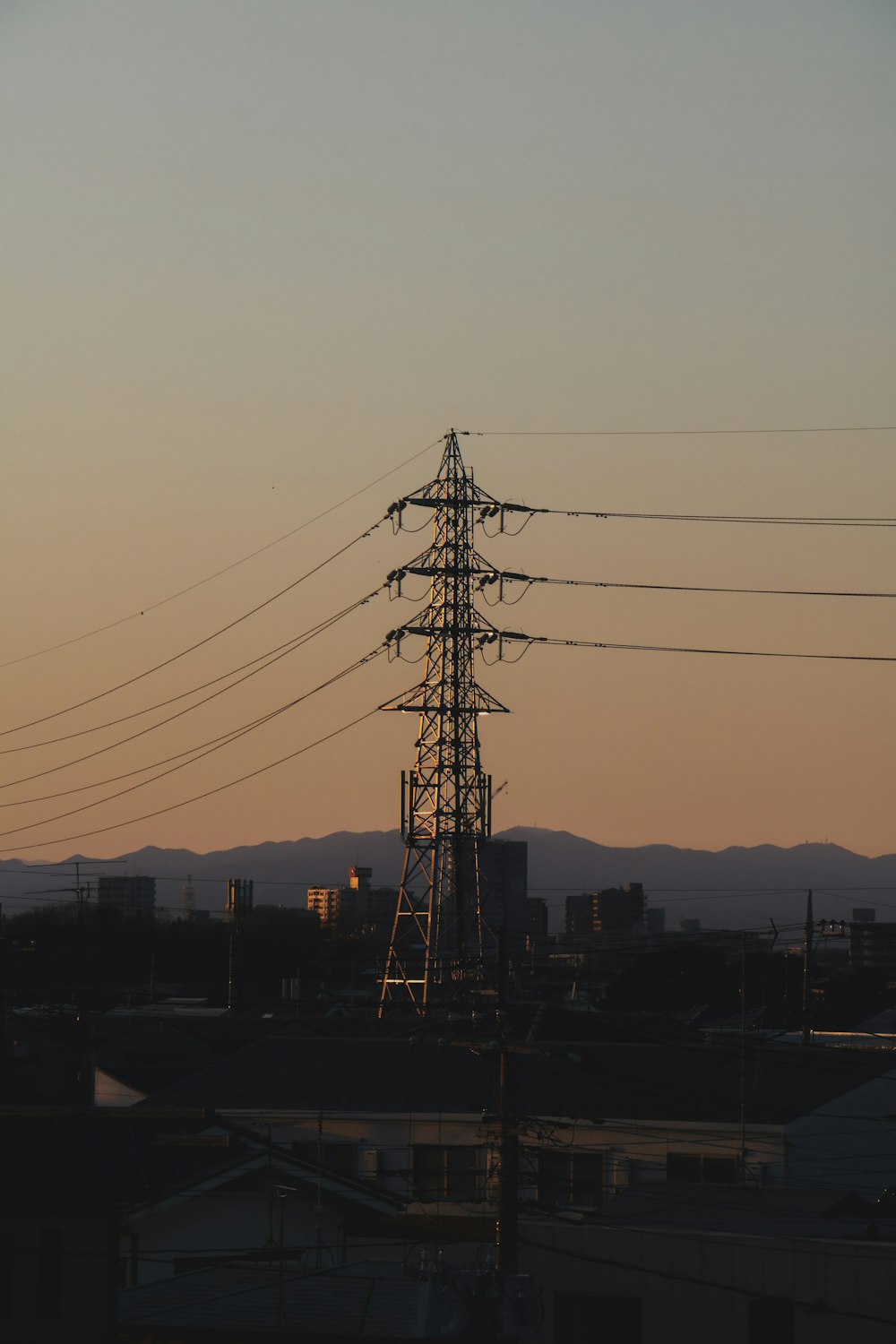 silhouette of electric post during sunset