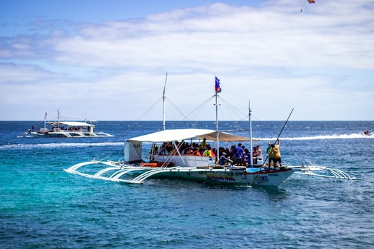 blue and white boat on sea during daytime in Cebu Philippines