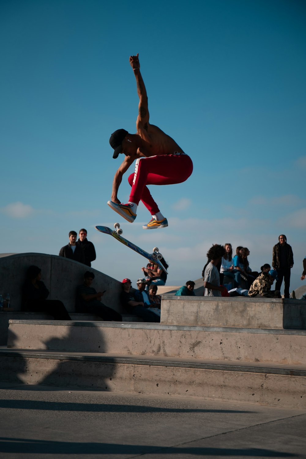 man in red tank top and blue denim jeans doing push up on stairs during daytime