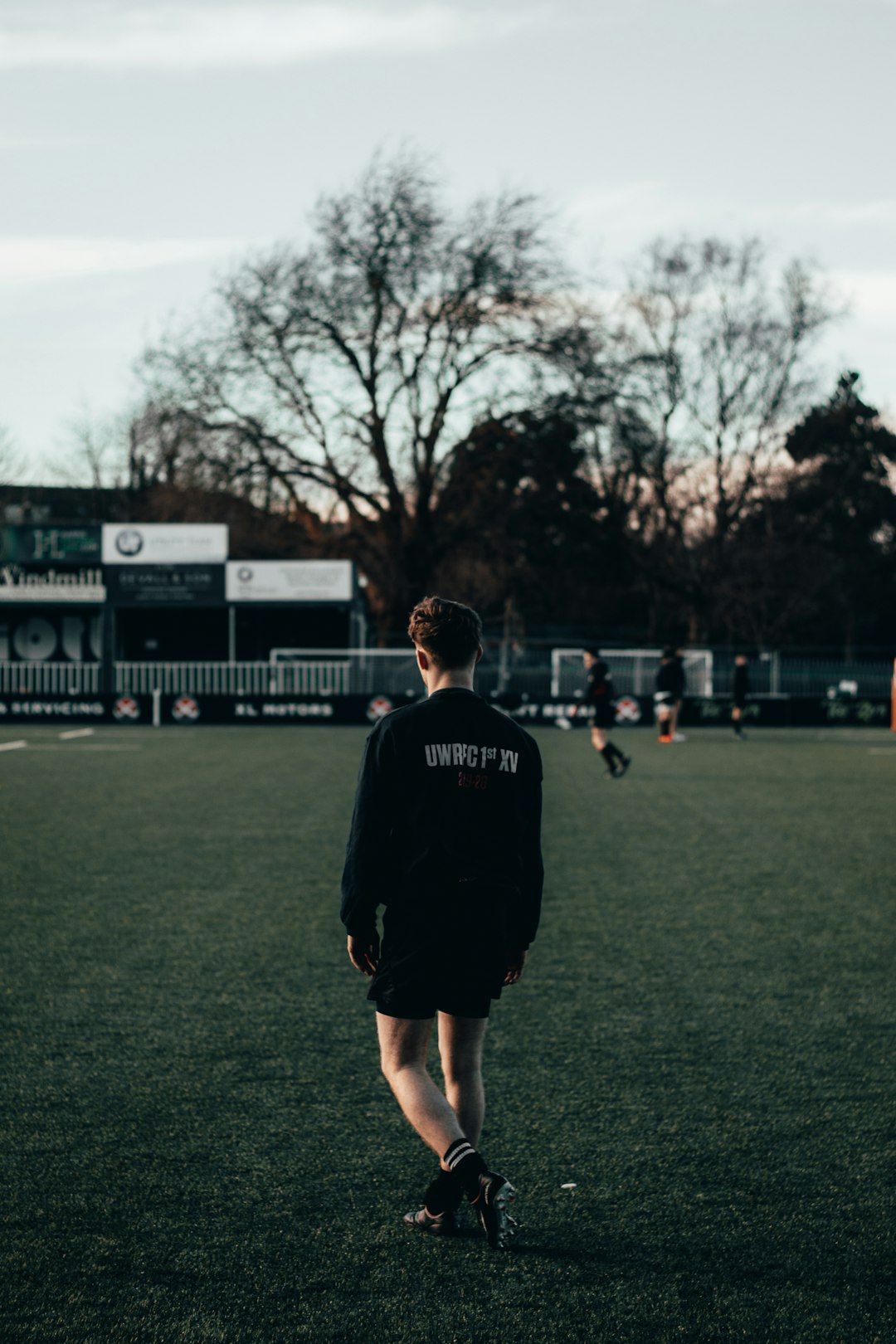 man in black nike crew neck t-shirt standing on green grass field during daytime